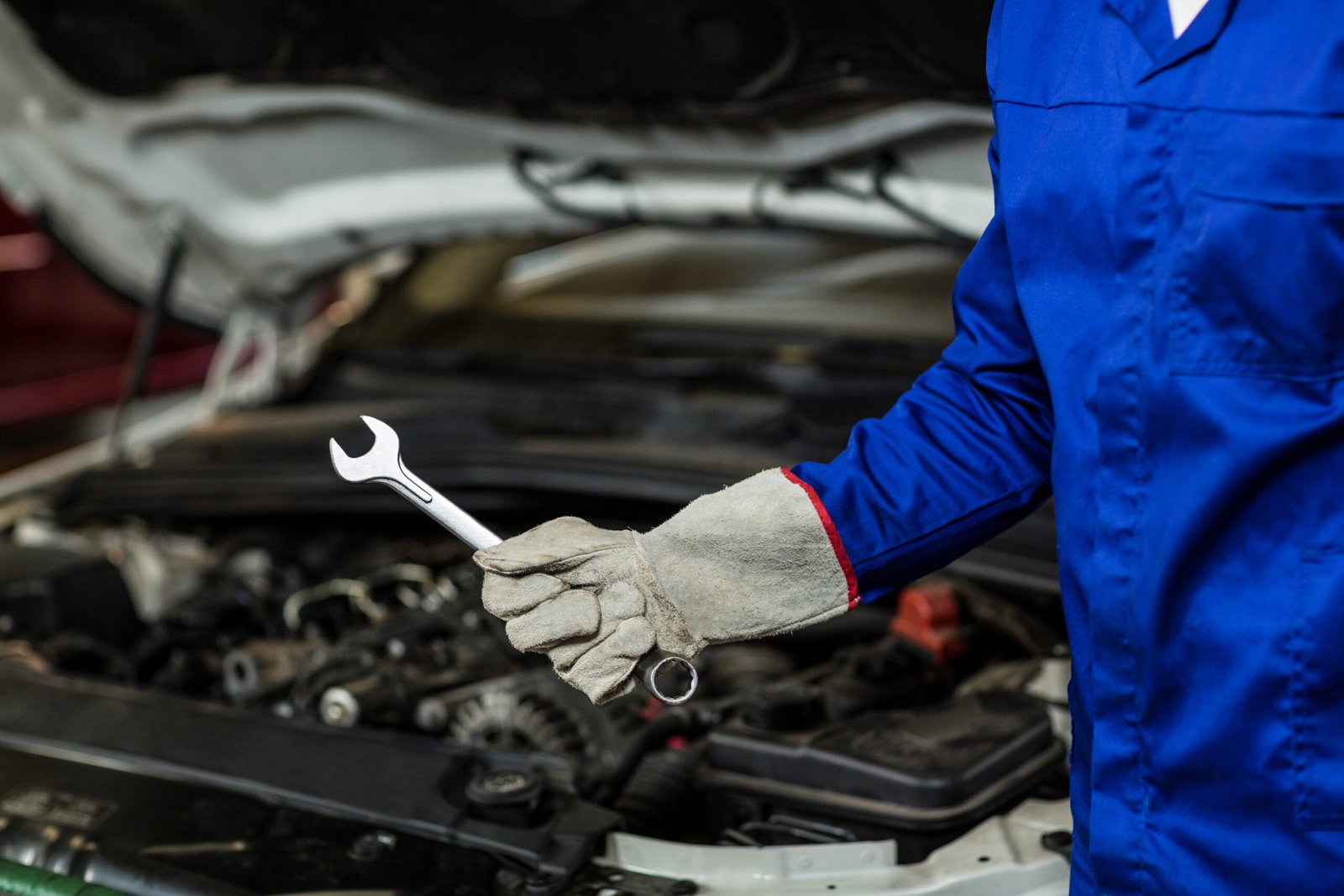 Mid-section of mechanic holding wrench tool in repair garage