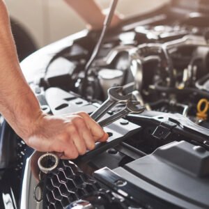 Picture showing muscular car service worker repairing vehicle.